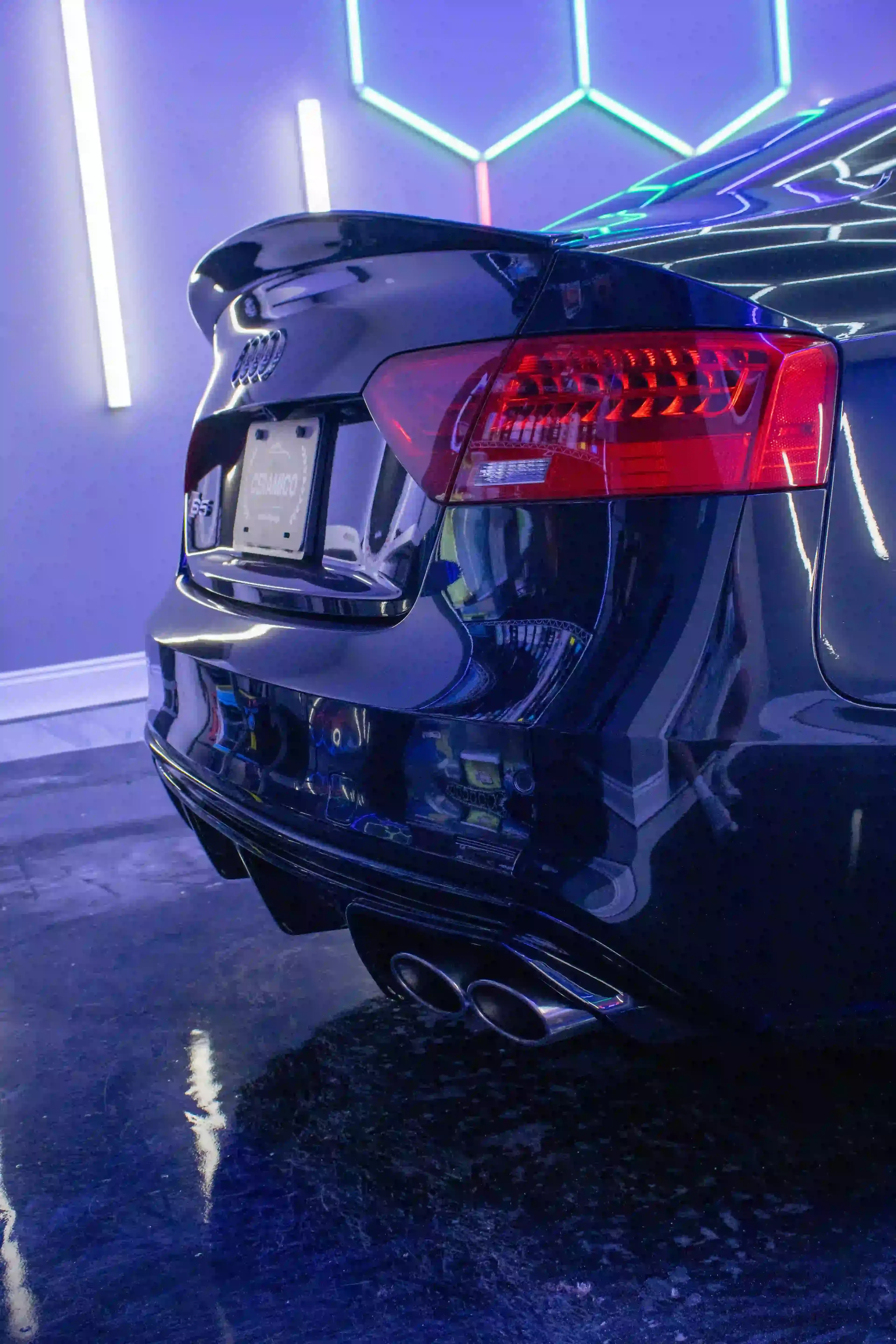 Audi rear diffuser and taillights with ceramic coating detail under shop lights