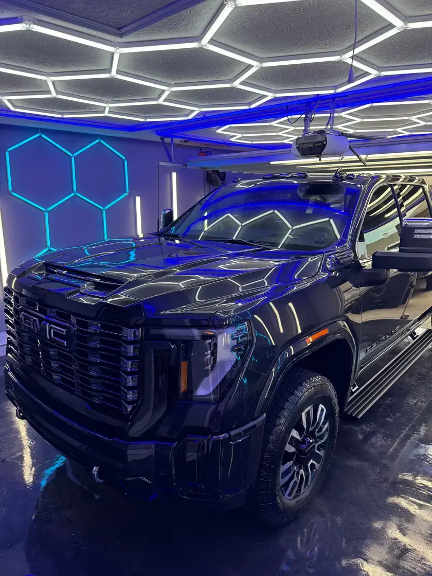 Black 2026 GMC Sierra Denali 3500 with a fresh 3 year ceramic coating under the hex lights at Ceramico in Panama City FL