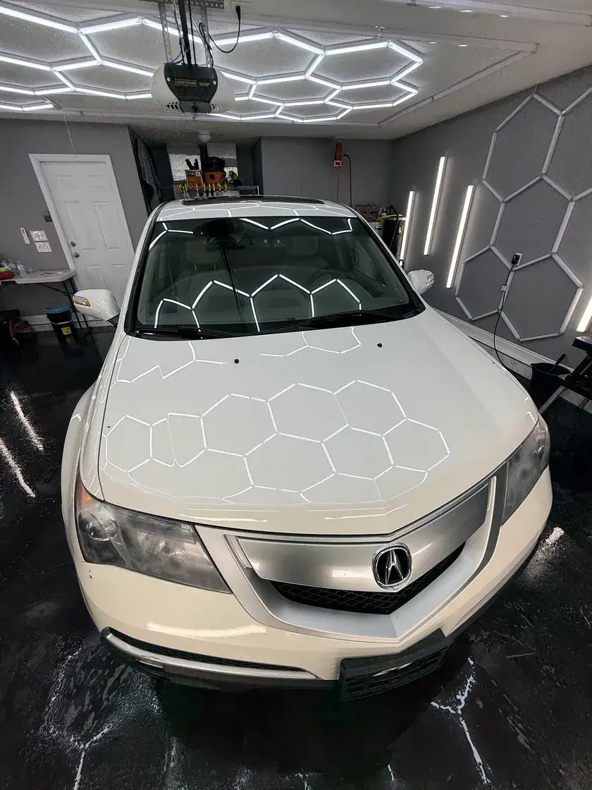 White 2011 Acura MDX with the hex lights reflected in the hood after a full detail at Ceramico in Panama City FL