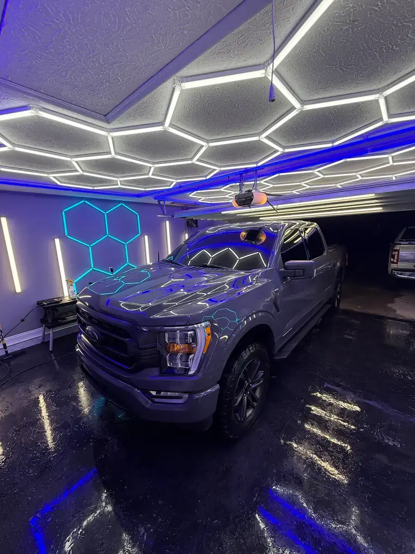 Grey 2021 Ford F-150 PowerBoost after a full interior and exterior detail under the hex lights at Ceramico in Panama City FL