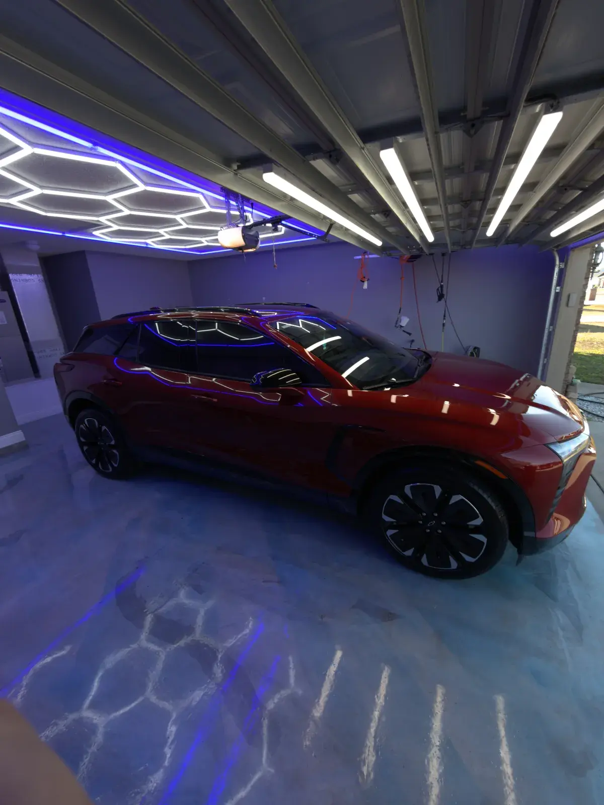 Rear three-quarter view of a ceramic coated 2024 Chevy Blazer EV showing the shop light reflections in the red paint