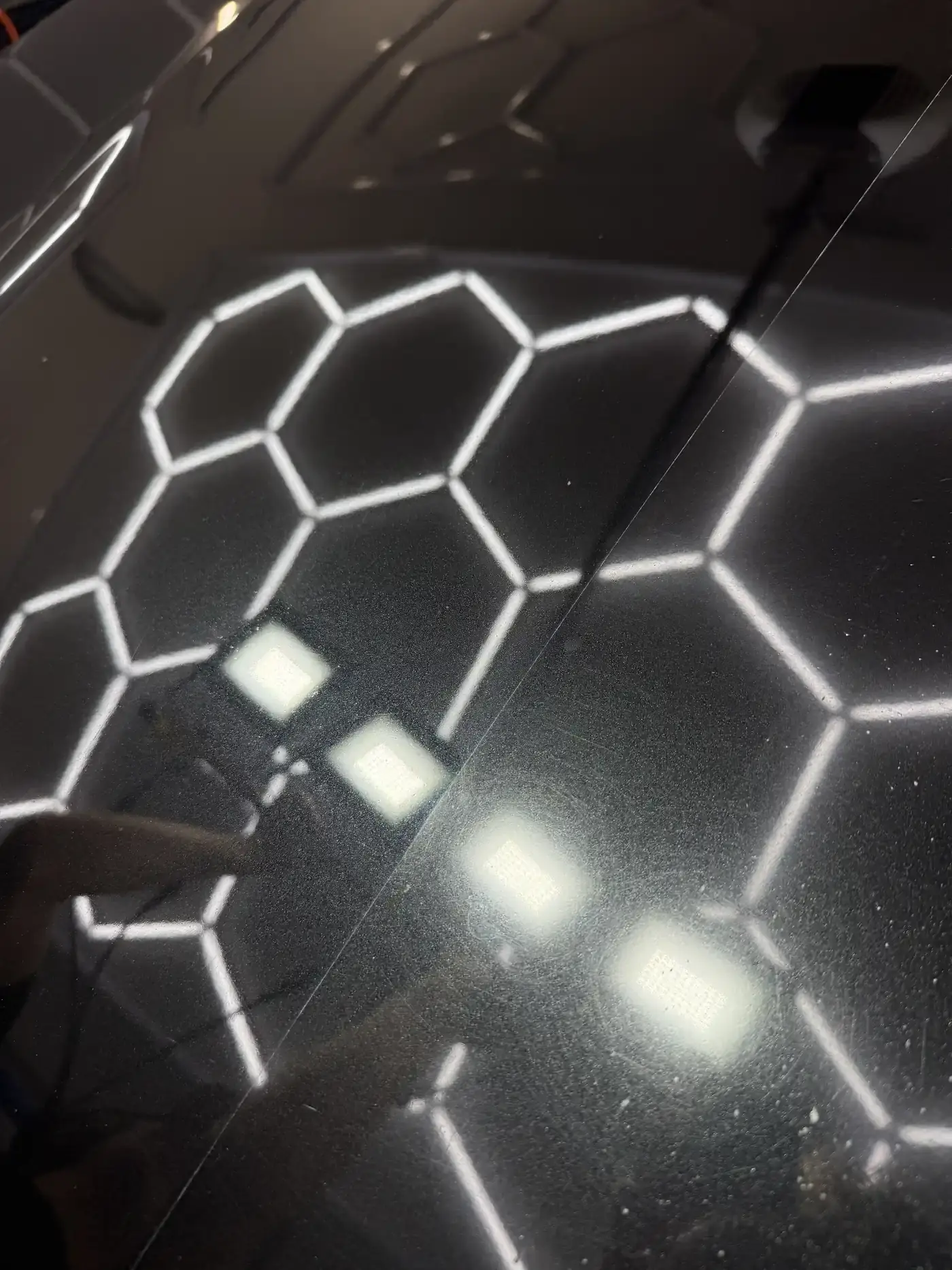 Half corrected black BMW panel showing the difference paint correction makes in Panama City FL