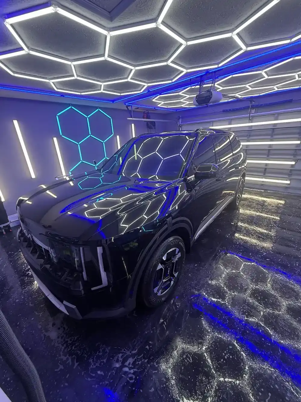Black 2027 Kia Telluride under the hex shop lights after a full detail in Panama City FL