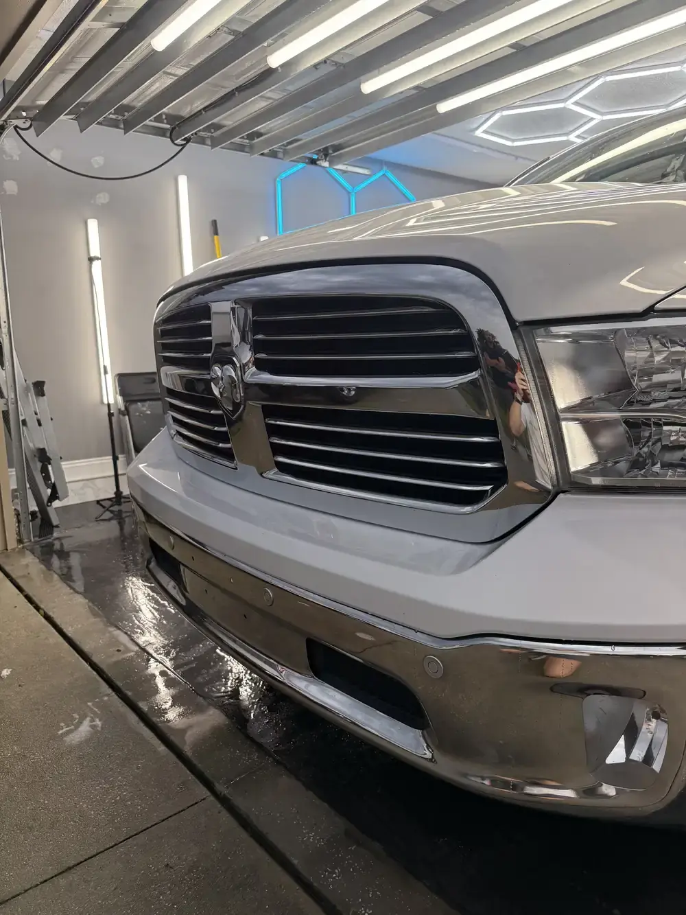 White 2019 Ram 1500 front end under the hex shop lights after a full interior and exterior detail in Panama City FL