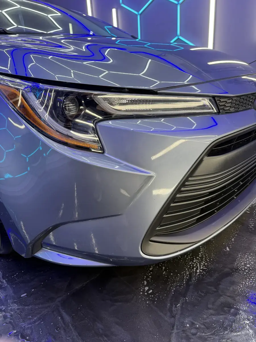 Glossy front fender, headlight and clean wheel on a Toyota Corolla after a full detail in Panama City FL