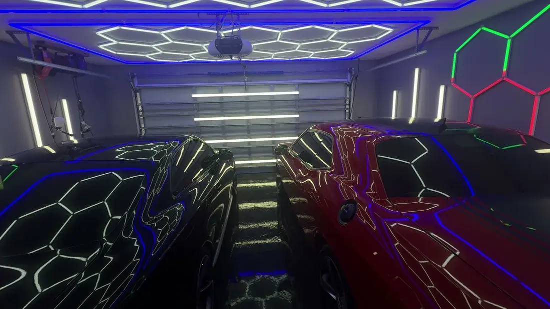 Two coated cars either side of the Ceramico garage in Panama City FL under full hex LED lighting