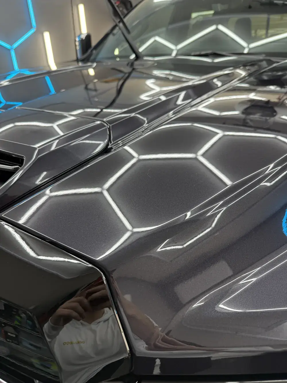 Hex shop lights reflecting in the coated hood of a 2026 GMC Denali 3500 in Panama City FL