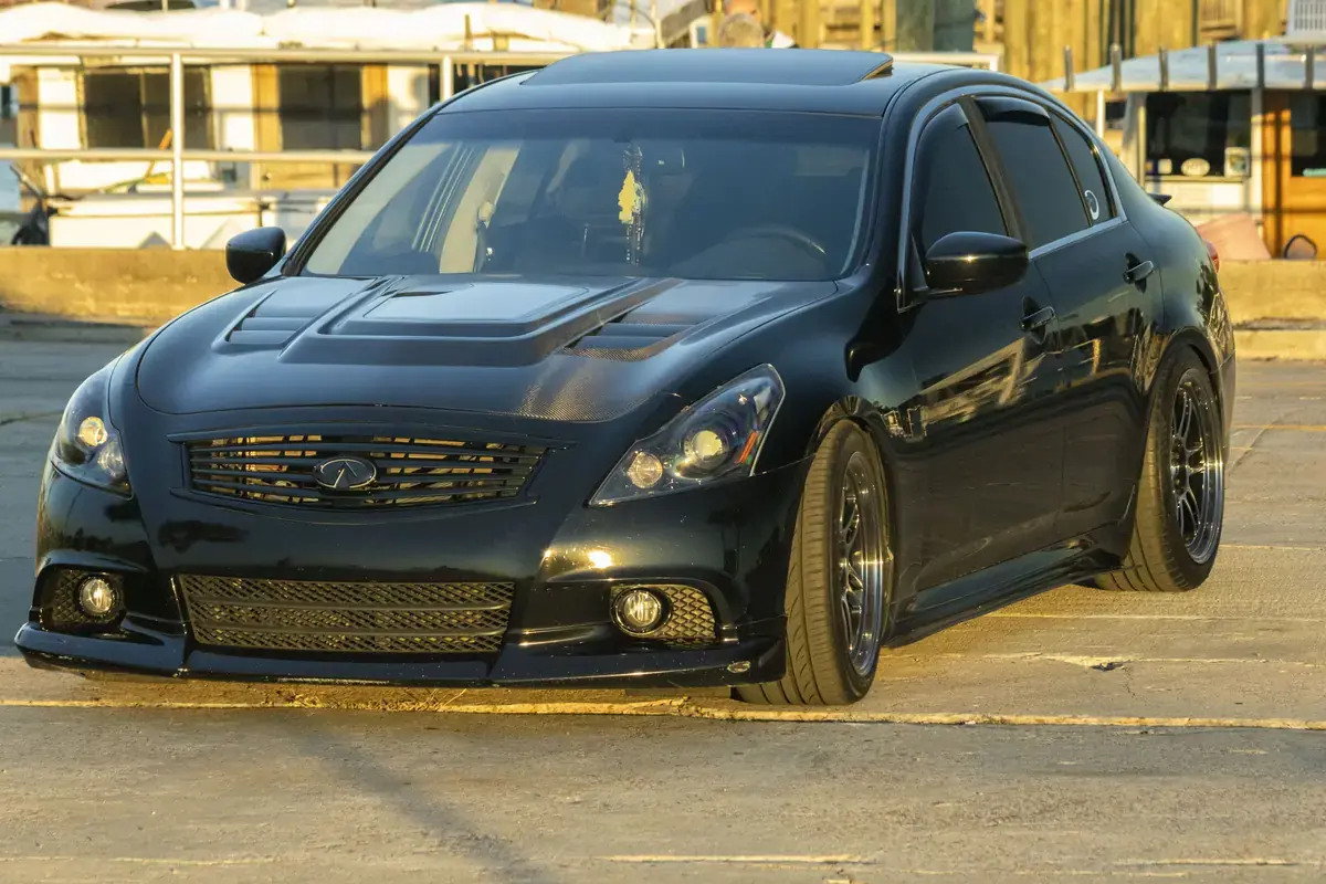 Black 2012 Infiniti G37 with a fresh ceramic coating parked at the Panama City marina at sunset