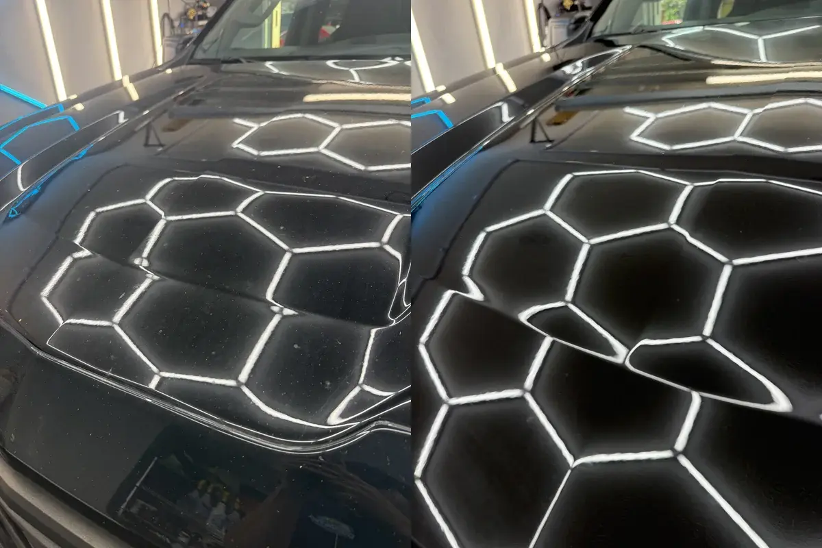 Before and after of the dusty, water spotted hood on a black Chevy Silverado during a full detail in Panama City FL